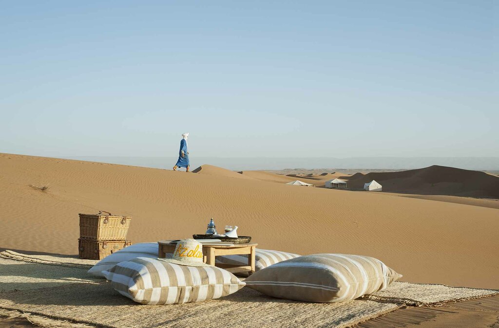 A camel caravan walking across sand dunes
